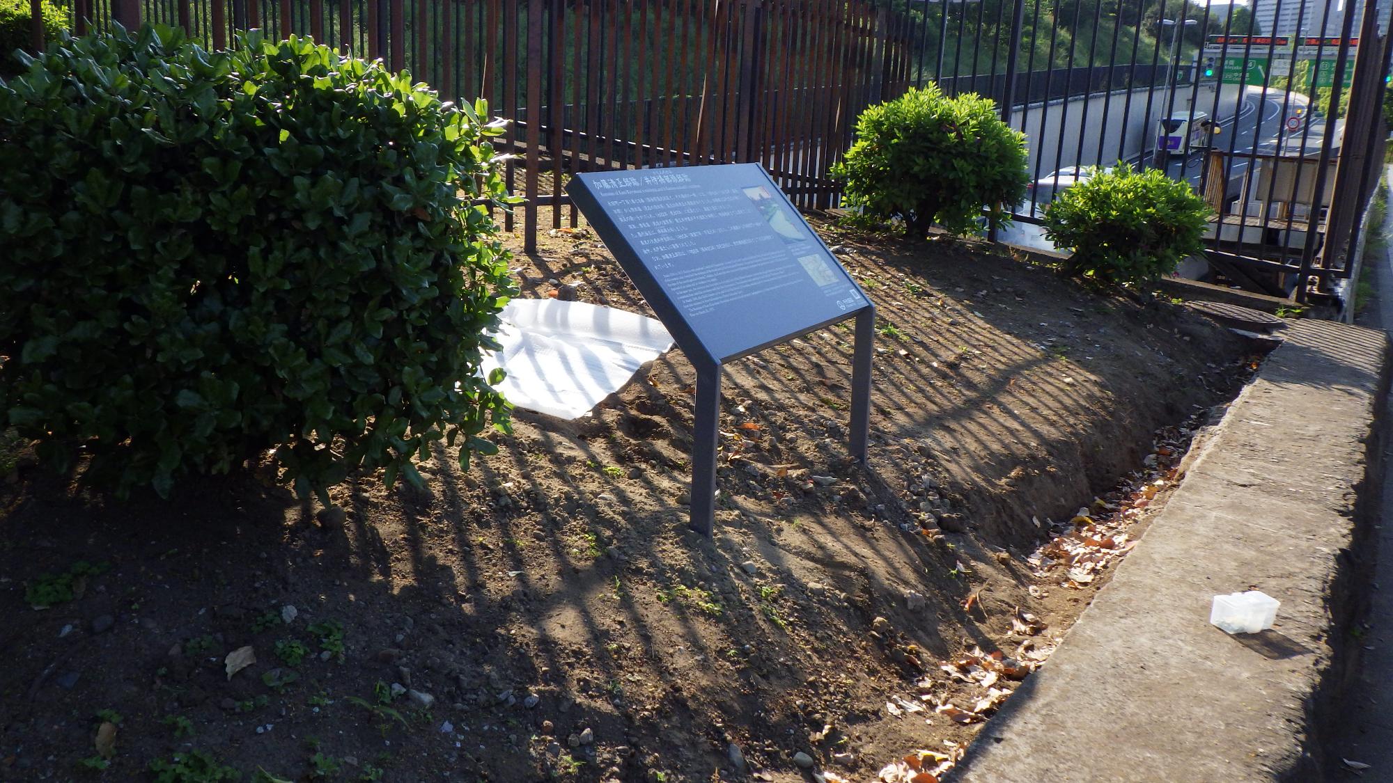 公園西側の一角に設置された加藤清正邸/井伊掃部頭邸跡の説明板に日が差している写真
