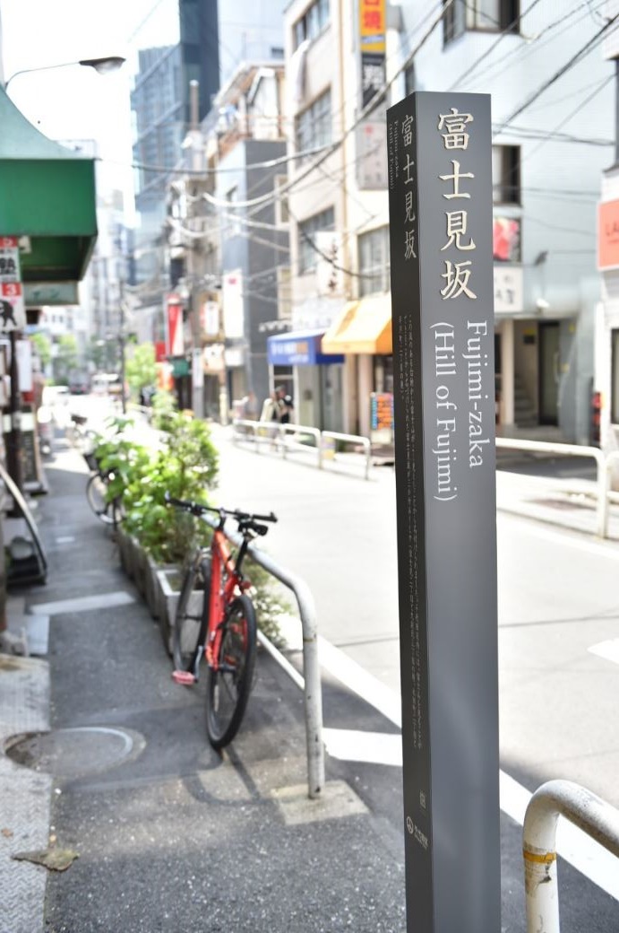 道路沿いに設置された富士見坂（神田小川町）の標柱の写真