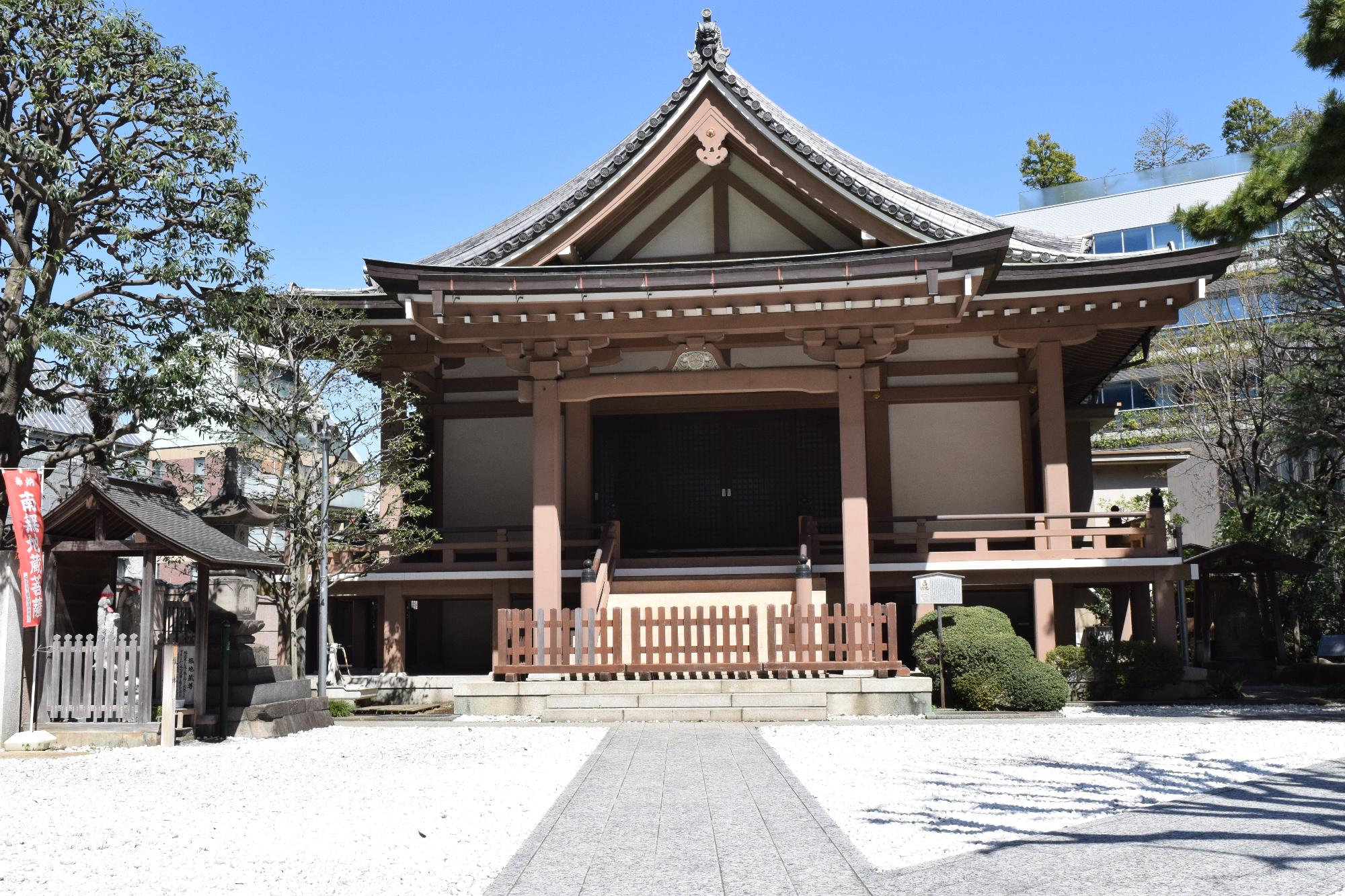 歩道の奥に建つ木造建築の常栄山心法寺を写した写真