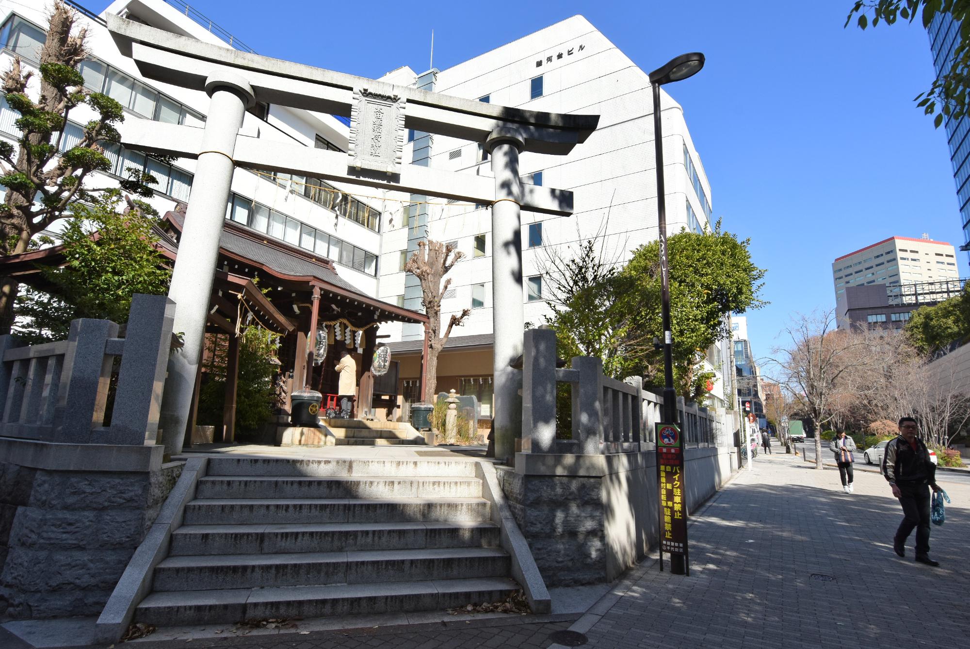道路脇に鳥居に続く階段があり、鳥居の奥に拝殿が見える太田姫稲荷神社の写真
