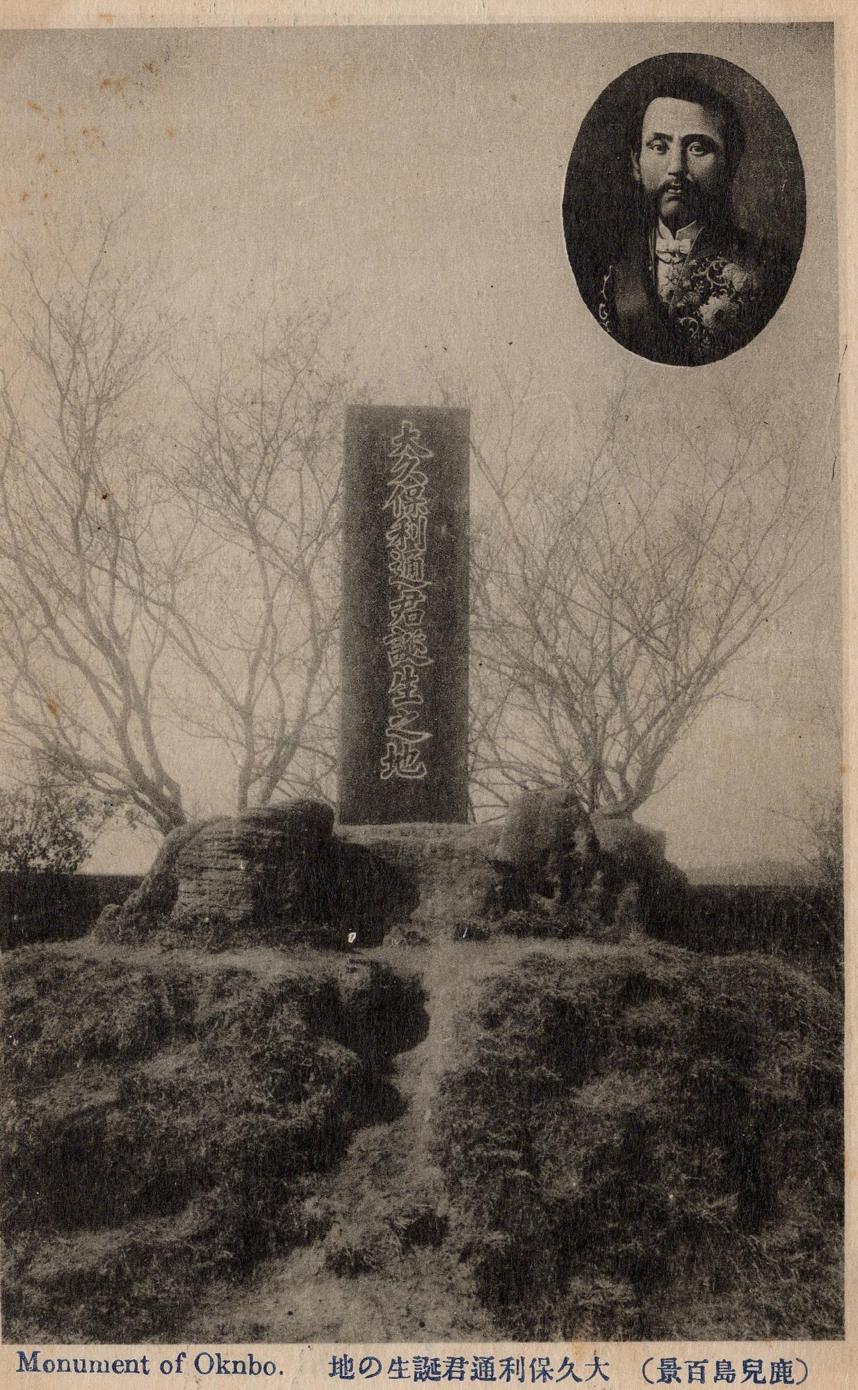 丘の上の葉っぱがついていない枝に囲われた大久保利通君誕生之地と書かれた石碑と右上に肖像画がある白黒写真