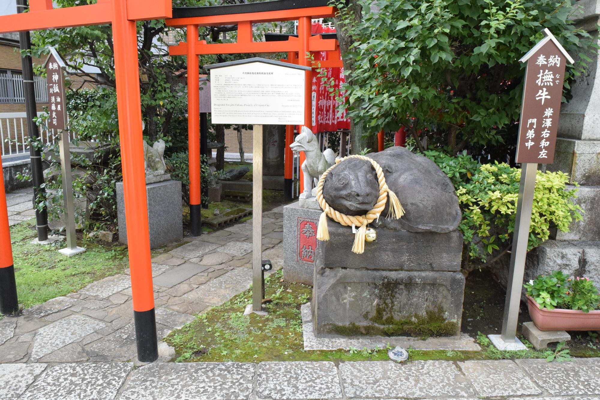 お稲荷さんの鳥居横にある奉納撫牛と書かれた案内板と撫で牛さんの写真