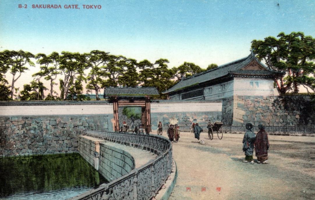 左にお堀がある桜田門の前を歩いている人達を描いた絵葉書を写した写真