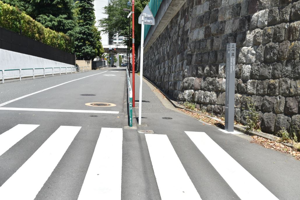 横断歩道の横に設置された三べ坂の標柱の写真