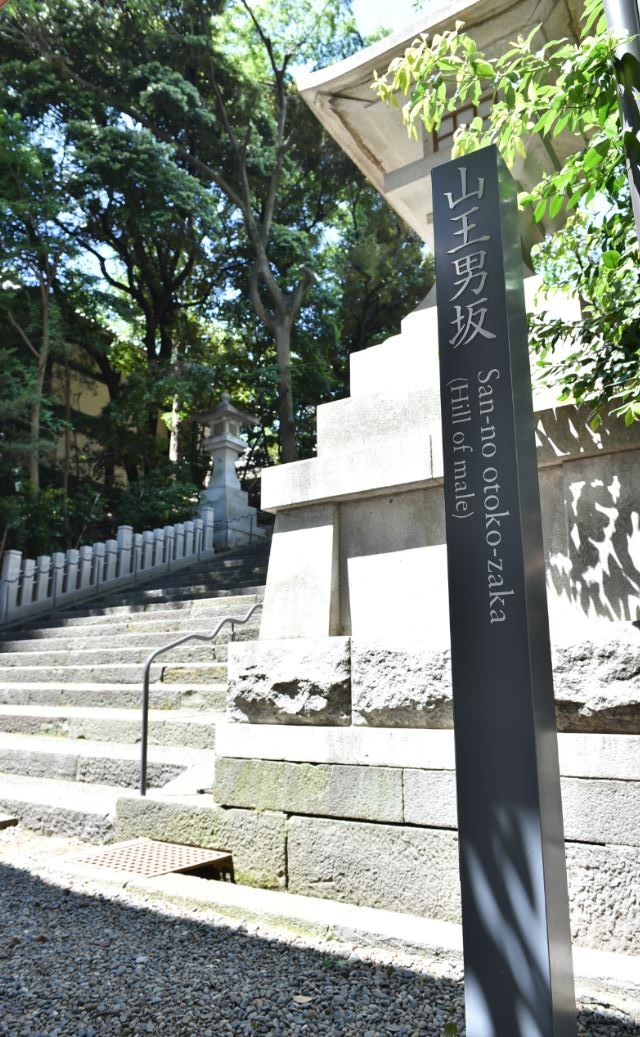 階段下石灯籠の前に設置された山王男坂の標柱の写真